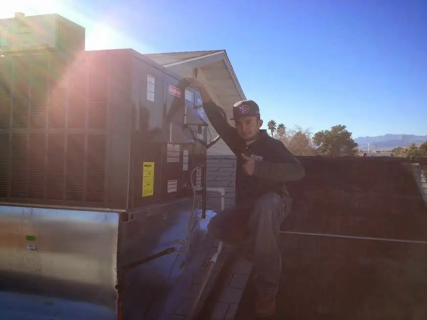 HVAC technician performing Air Duct Repair on a rooftop unit in Gold Canyon